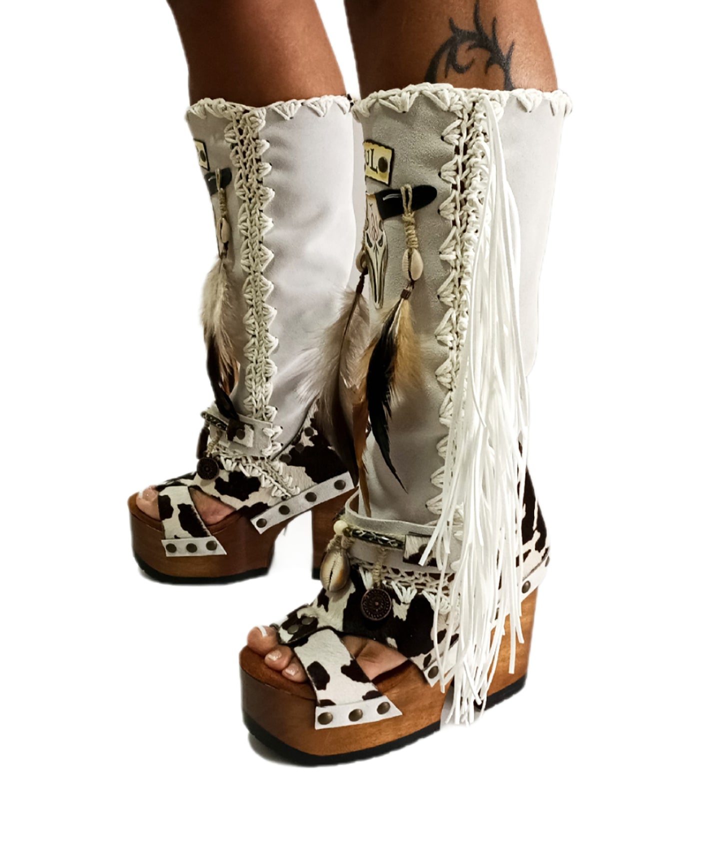 Handmade cowboy boots, white boots with cowhide and fringes. Cowboy style boots with hand painted buffalo, feathers, coins and natural shells. Vintage style platform boots. High-end leather footwear handmade by Sol Caleyo.