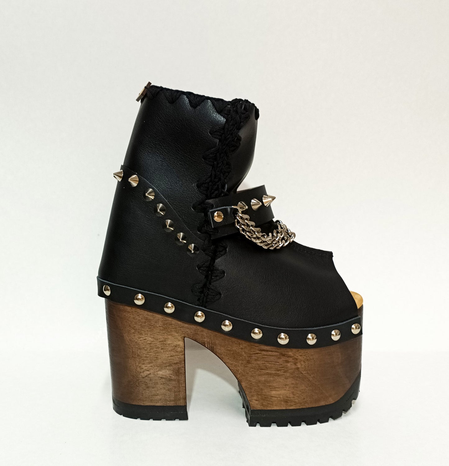 Black leather platform boot. Leather boot with super high wooden heel. Leather peep toe boot decorated with studs and silver chains. Platform boots with platform heel. Sizes 34 to 47. High quality leather shoes handmade by sol Caleyo. Sustainable fashion.
