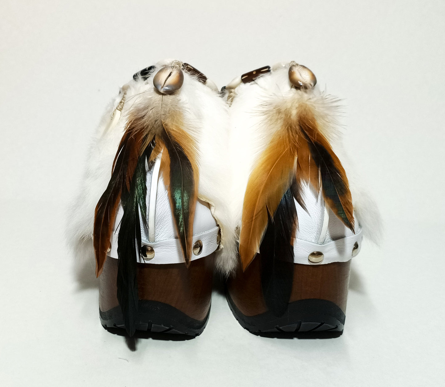 White leather and rabbit fur clogs in bohemian style, decorated with feathers, horns and natural shells. White leather mule clogs with super high heel. Sizes 34 to 47. High quality leather shoes handmade by Sol Caleyo.