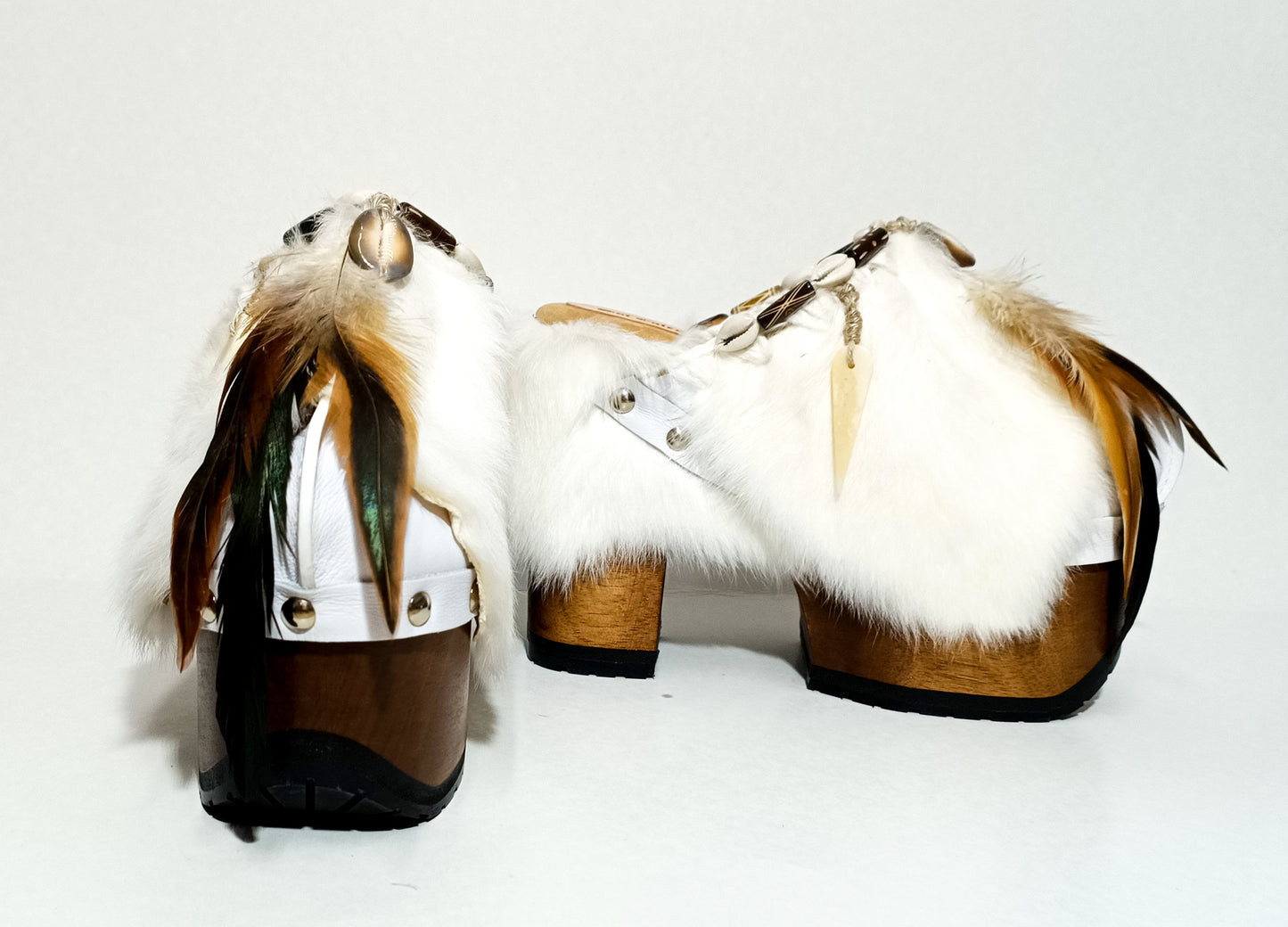 White leather and rabbit fur clogs in bohemian style, decorated with feathers, horns and natural shells. White leather mule clogs with super high heel. Sizes 34 to 47. High quality leather shoes handmade by Sol Caleyo.