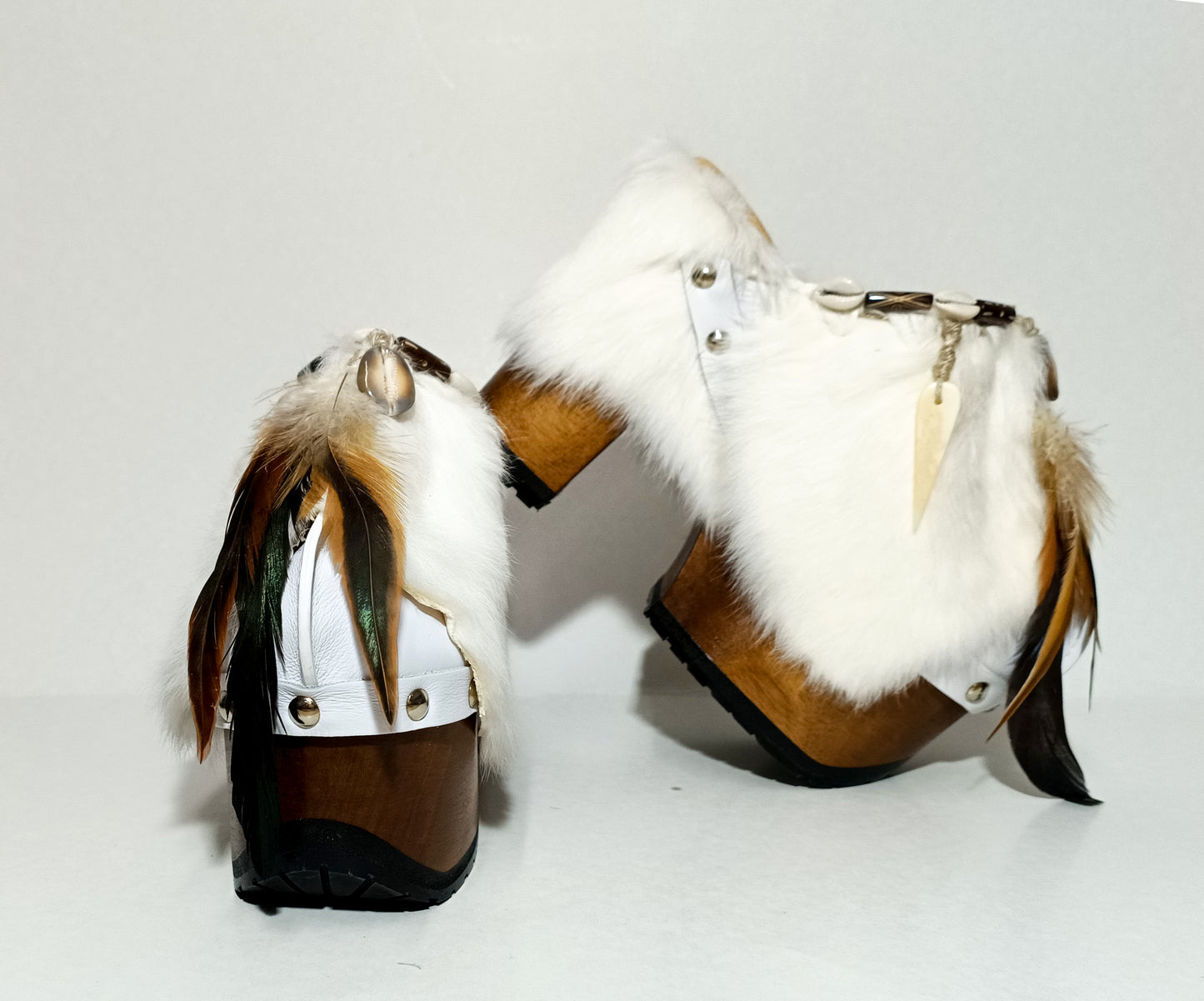 White leather and rabbit fur clogs in bohemian style, decorated with feathers, horns and natural shells. White leather mule clogs with super high heel. Sizes 34 to 47. High quality leather shoes handmade by Sol Caleyo.