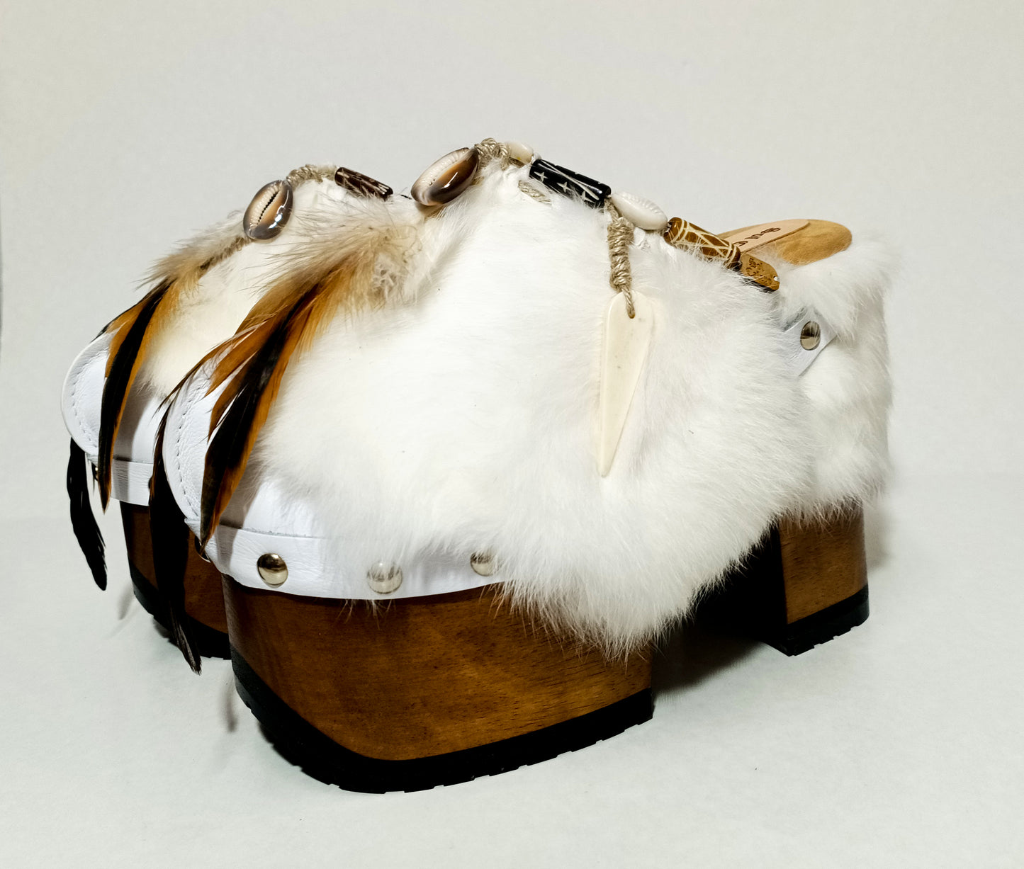 White leather and rabbit fur clogs in bohemian style, decorated with feathers, horns and natural shells. White leather mule clogs with super high heel. Sizes 34 to 47. High quality leather shoes handmade by Sol Caleyo.