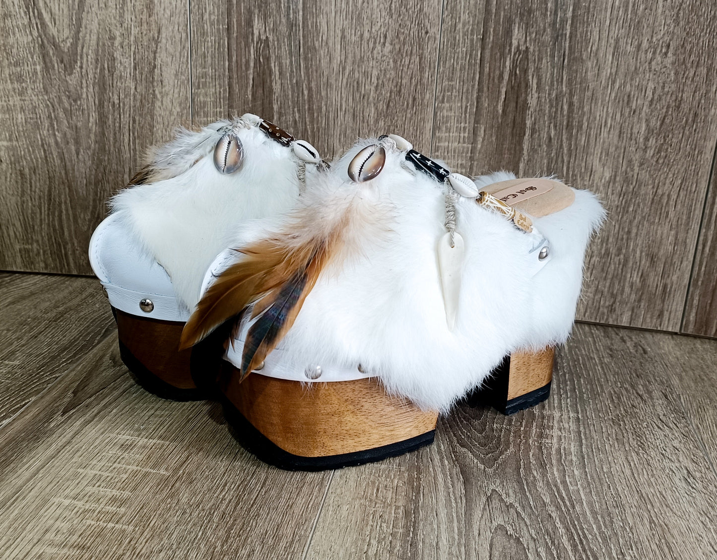 White leather and rabbit fur clogs in bohemian style, decorated with feathers, horns and natural shells. White leather mule clogs with super high heel. Sizes 34 to 47. High quality leather shoes handmade by Sol Caleyo.