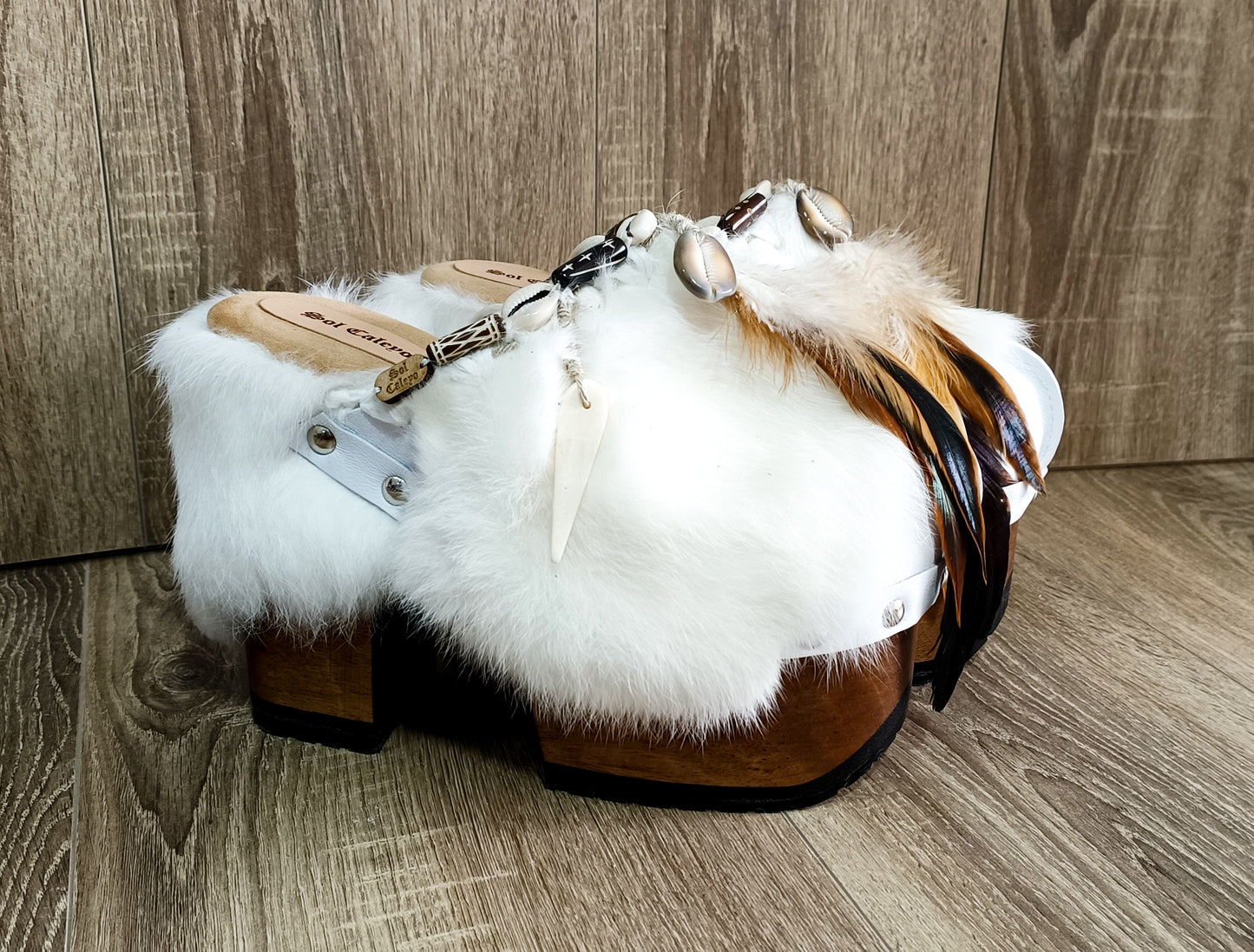 White leather and rabbit fur clogs in bohemian style, decorated with feathers, horns and natural shells. White leather mule clogs with super high heel. Sizes 34 to 47. High quality leather shoes handmade by Sol Caleyo.