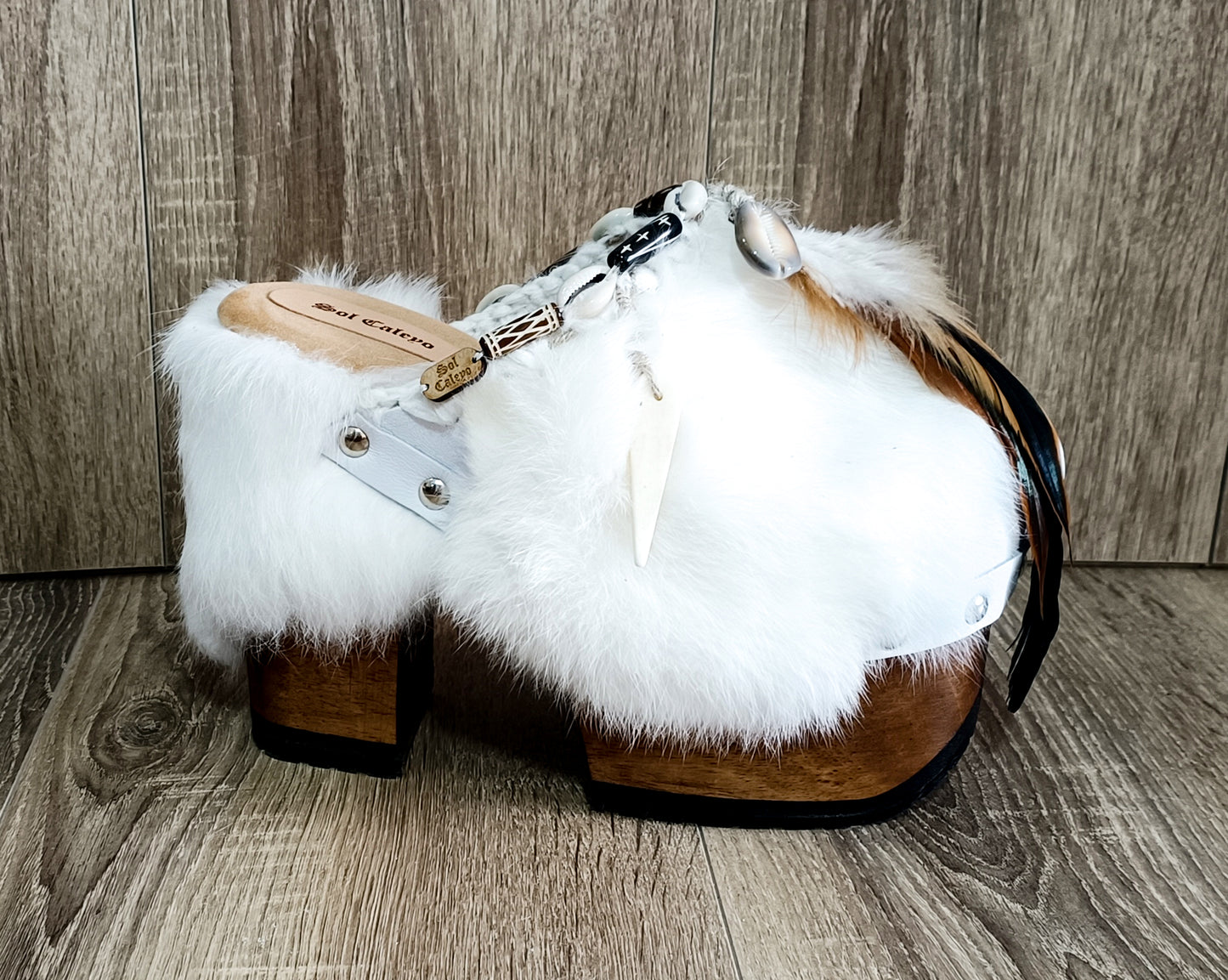 White leather and rabbit fur clogs in bohemian style, decorated with feathers, horns and natural shells. White leather mule clogs with super high heel. Sizes 34 to 47. High quality leather shoes handmade by Sol Caleyo.