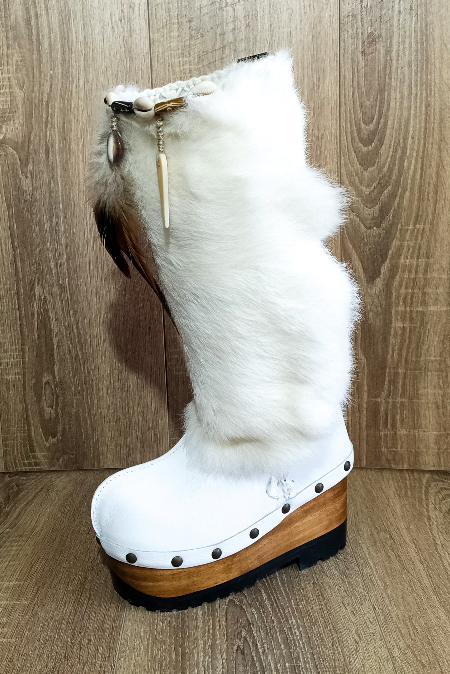 White fur boots with wooden wedge. White bohemian style leather boots. Handmade clogs shoes. White fur boots decorated with feathers, natural shells and horns. High-end handmade footwear by Sol Caleyo. Handmade Furry Shoes.