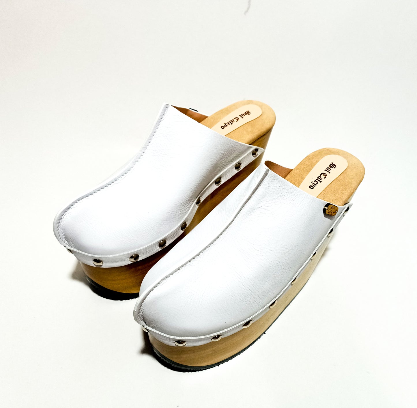 Vintage style clogs with wooden wedge. White clogs 70s style. White mules with wedge heel. High-end handmade footwear by Sol Caleyo.
