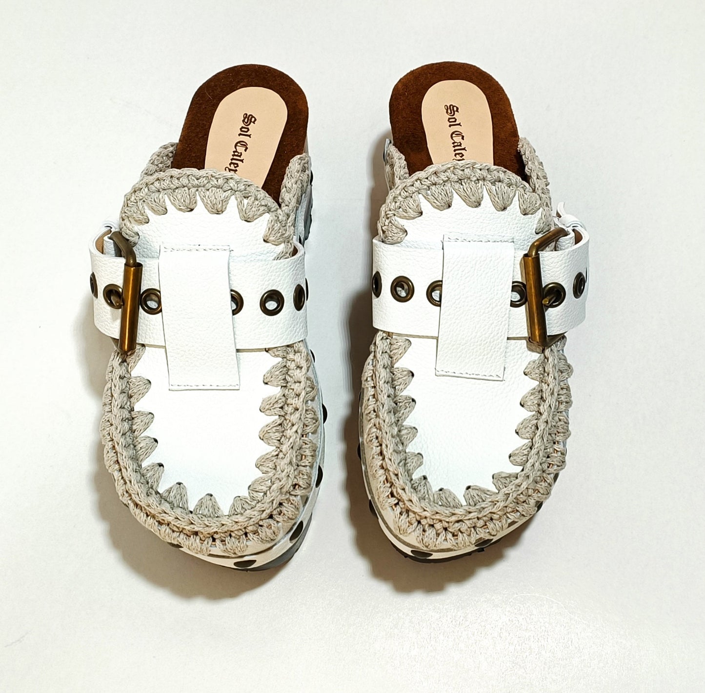 White wooden wedge clogs. White leather mules. Oxford style buckle clogs. High quality handmade shoes by Sol Caleyo.
