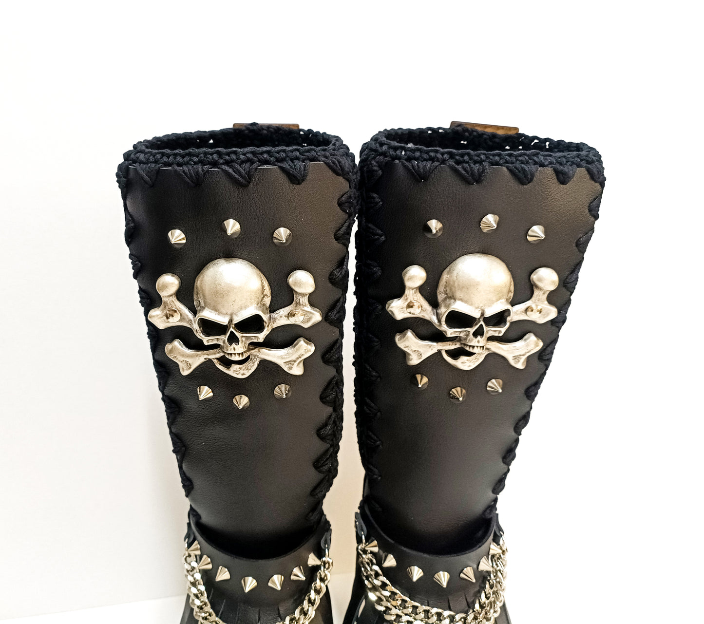 Handcrafted Sol Caleyo black leather boots featuring a wenge wooden platform, embellished with old silver skulls, chains, and fringes in a gothic-chic style.