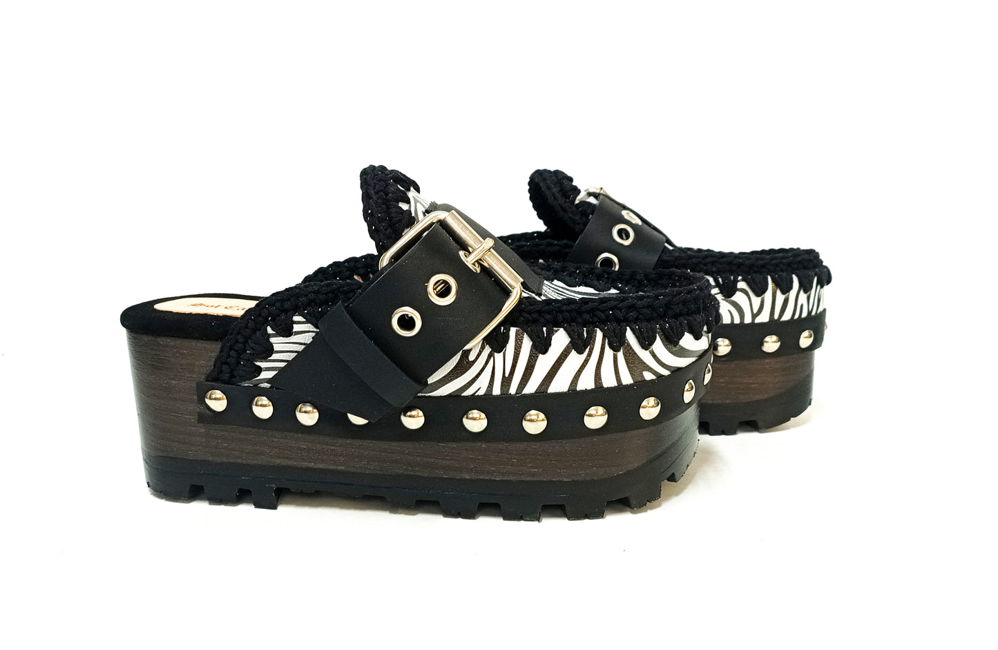 Handmade zebra leather mules. Oxford-style zebra leather clogs. Leather mules with wooden wedges. High-end footwear handmade by Sol Caleyo.