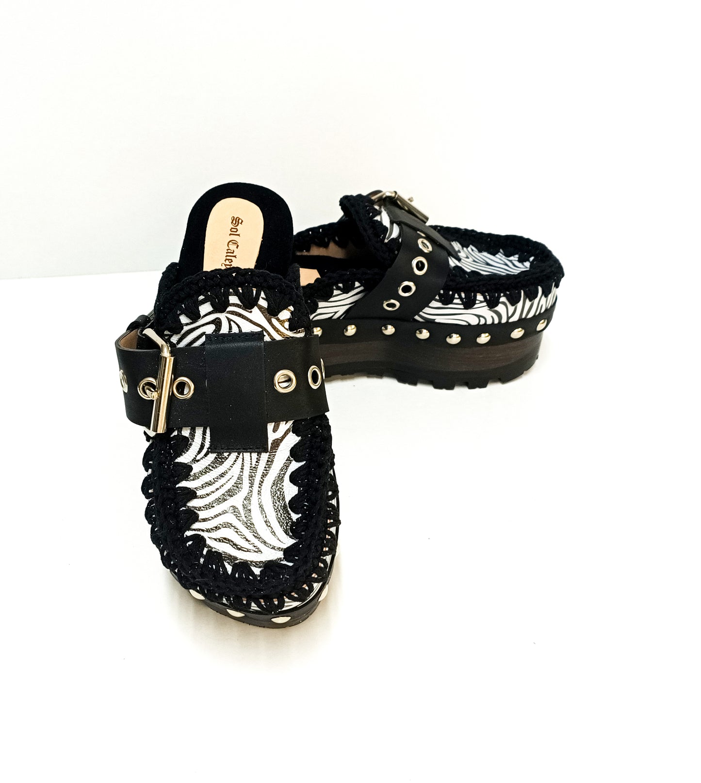 Handmade zebra leather mules. Oxford-style zebra leather clogs. Leather mules with wooden wedges. High-end footwear handmade by Sol Caleyo.