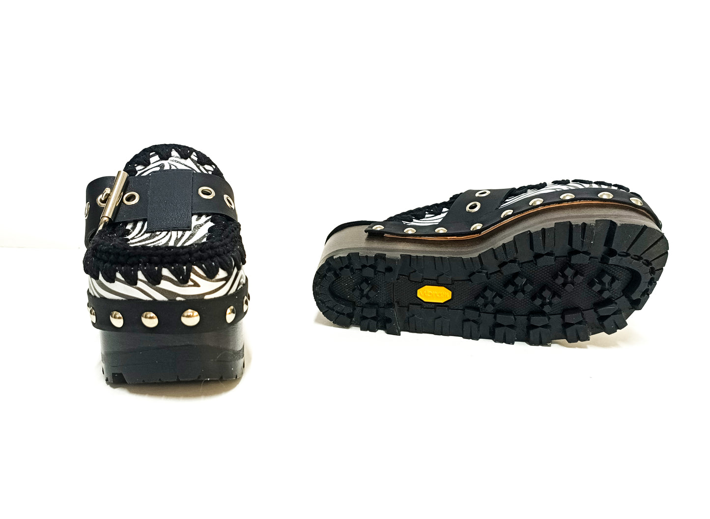 Handmade zebra leather mules. Oxford-style zebra leather clogs. Leather mules with wooden wedges. High-end footwear handmade by Sol Caleyo.