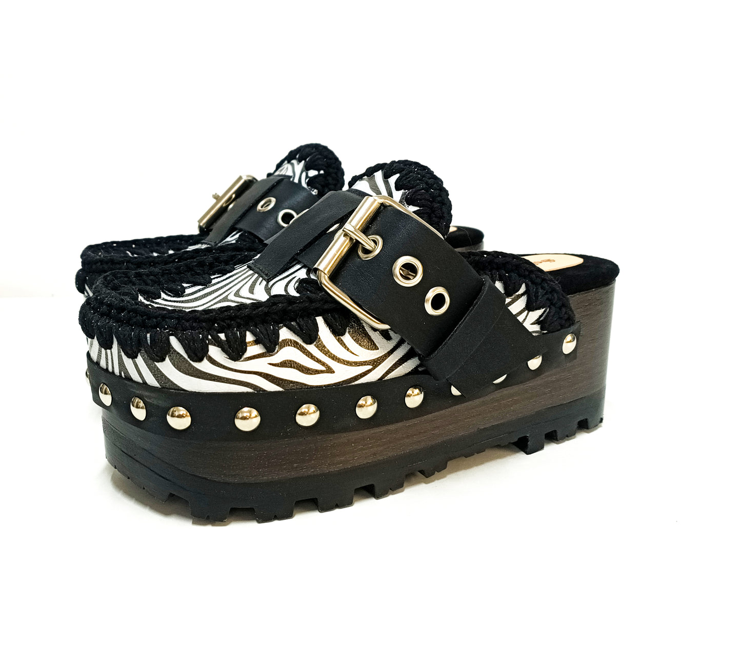Handmade zebra leather mules. Oxford-style zebra leather clogs. Leather mules with wooden wedges. High-end footwear handmade by Sol Caleyo.