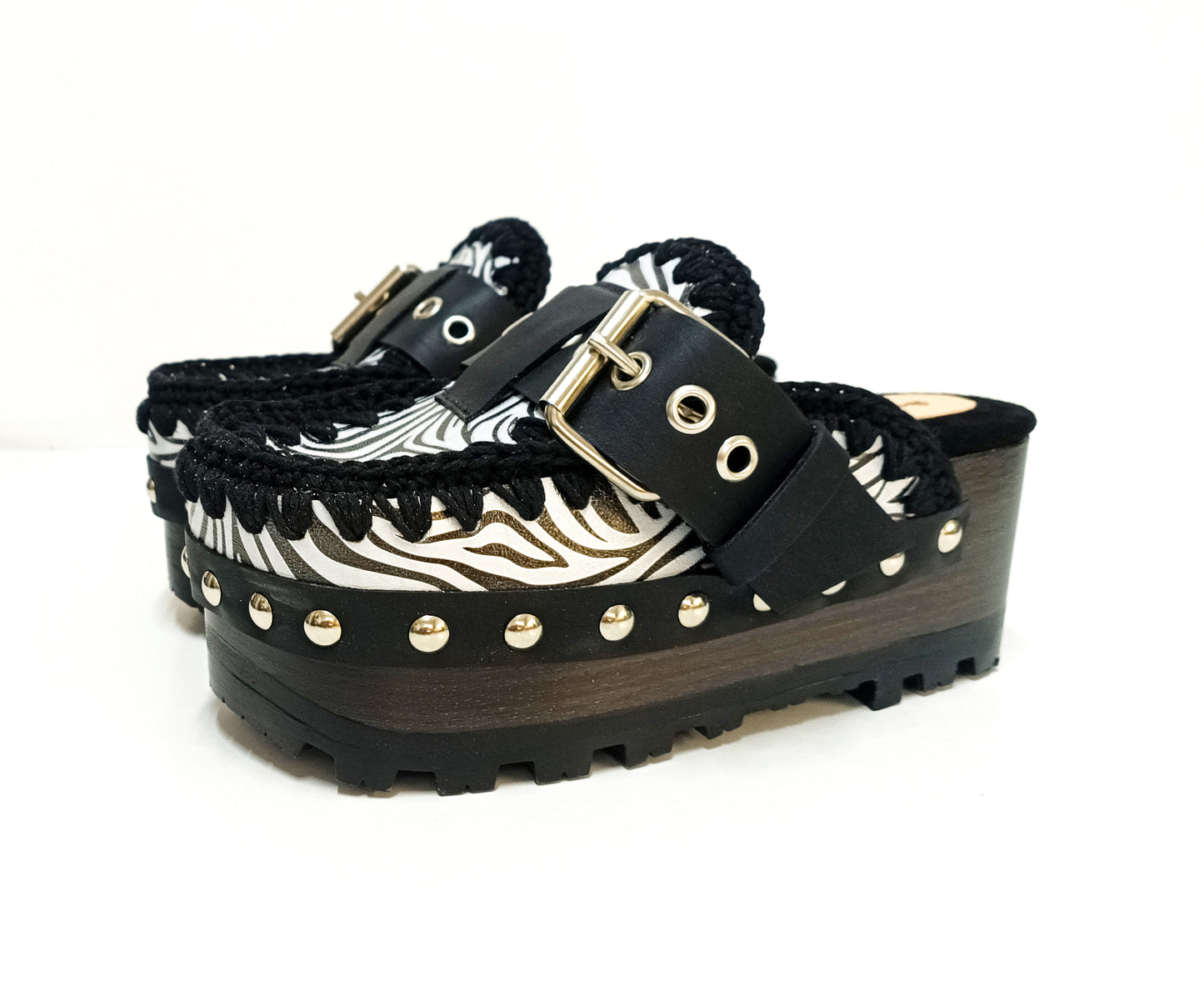Handmade zebra leather mules. Oxford-style zebra leather clogs. Leather mules with wooden wedges. High-end footwear handmade by Sol Caleyo.