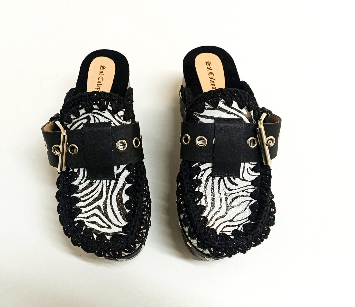 Handmade zebra leather mules. Oxford-style zebra leather clogs. Leather mules with wooden wedges. High-end footwear handmade by Sol Caleyo.
