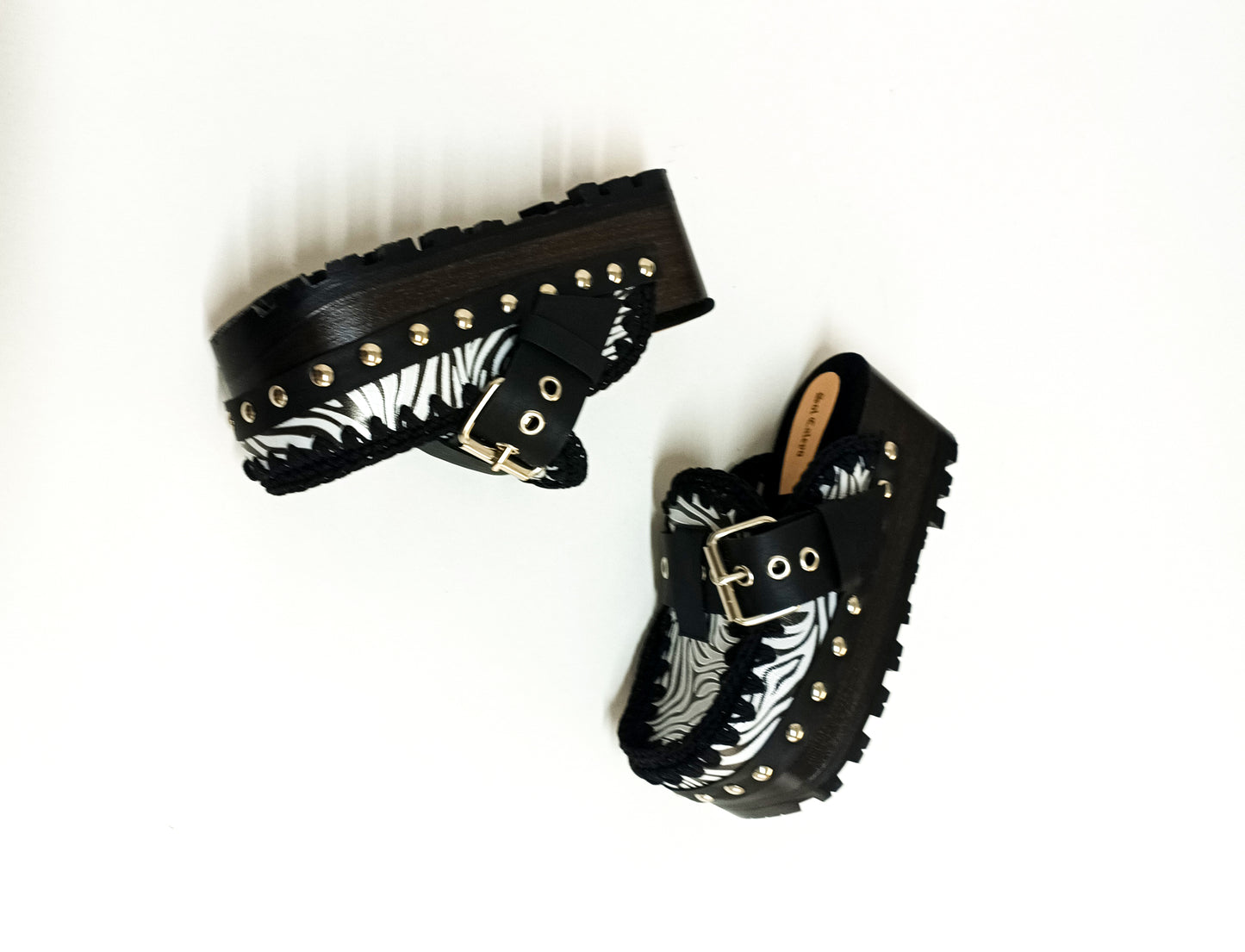 Handmade zebra leather mules. Oxford-style zebra leather clogs. Leather mules with wooden wedges. High-end footwear handmade by Sol Caleyo.