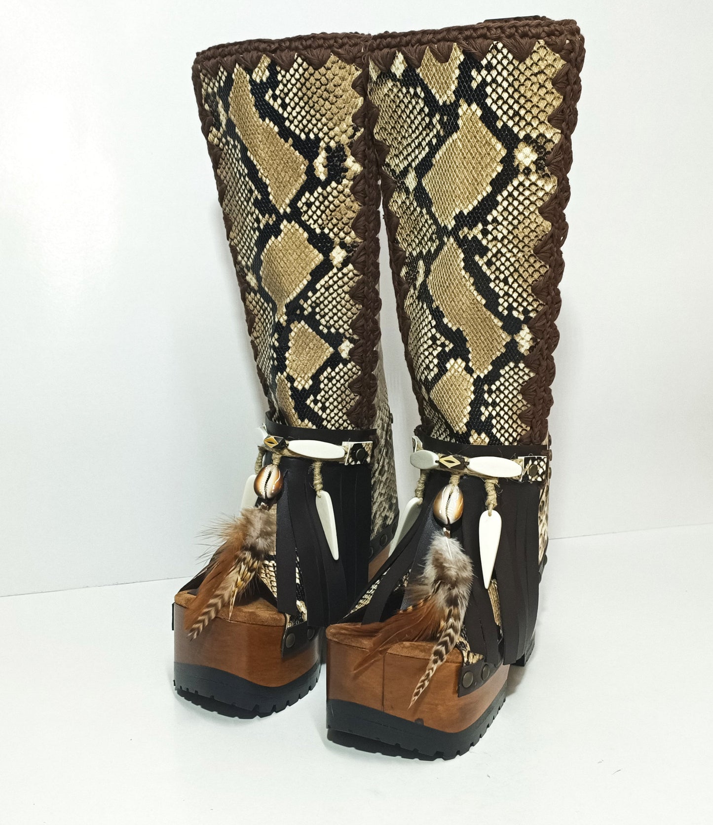 Close-up of wooden platform sole and antique gold studs on handcrafted bohemian snake leather boots