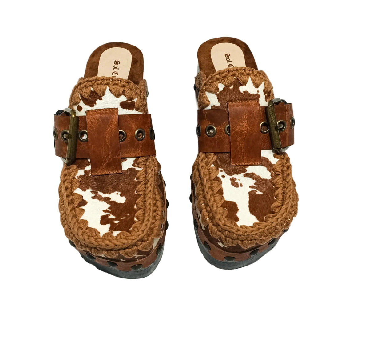 Oxford Clogs Cowhide Print by Sol Caleyo: handmade wooden platform clogs with cowhide hair-on leather, crochet trim, and aged camel leather strap.