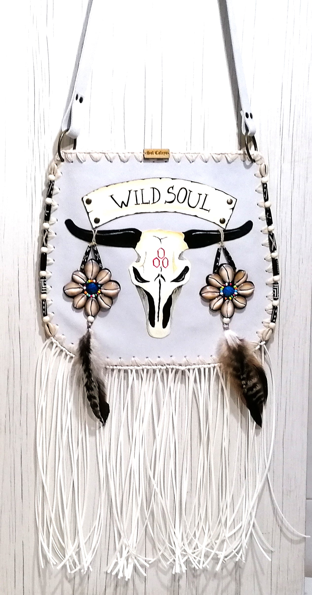 Elevate your bohemian style with this exquisite handmade suede leather bag, featuring a stunning buffalo head design that is hand-painted and intricately embroidered. Every detail is crafted by hand, ensuring a one-of-a-kind piece.