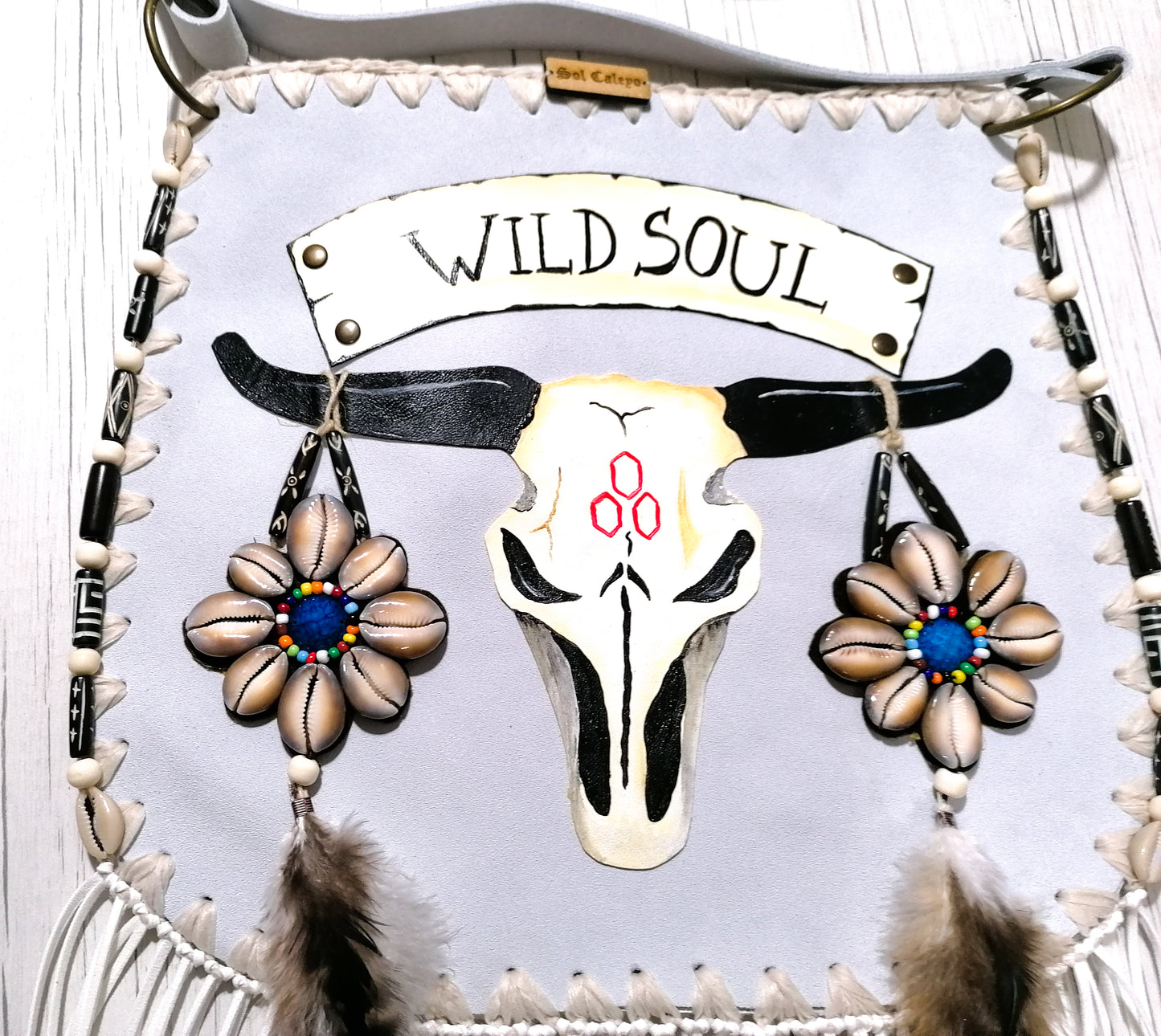 Elevate your bohemian style with this exquisite handmade suede leather bag, featuring a stunning buffalo head design that is hand-painted and intricately embroidered. Every detail is crafted by hand, ensuring a one-of-a-kind piece.