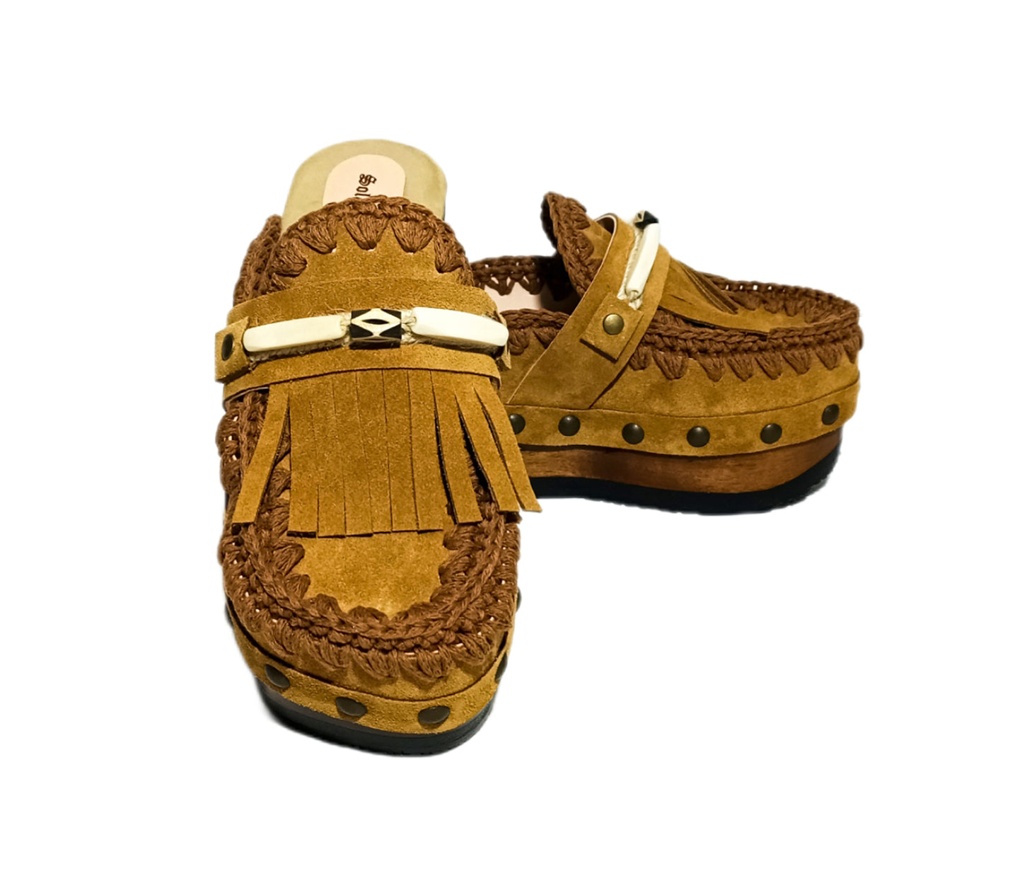 Moccasin style suede leather clogs, decorated with fringes and horns. Moccasin style leather mules. High-end footwear handmade by Sol Caleyo.
