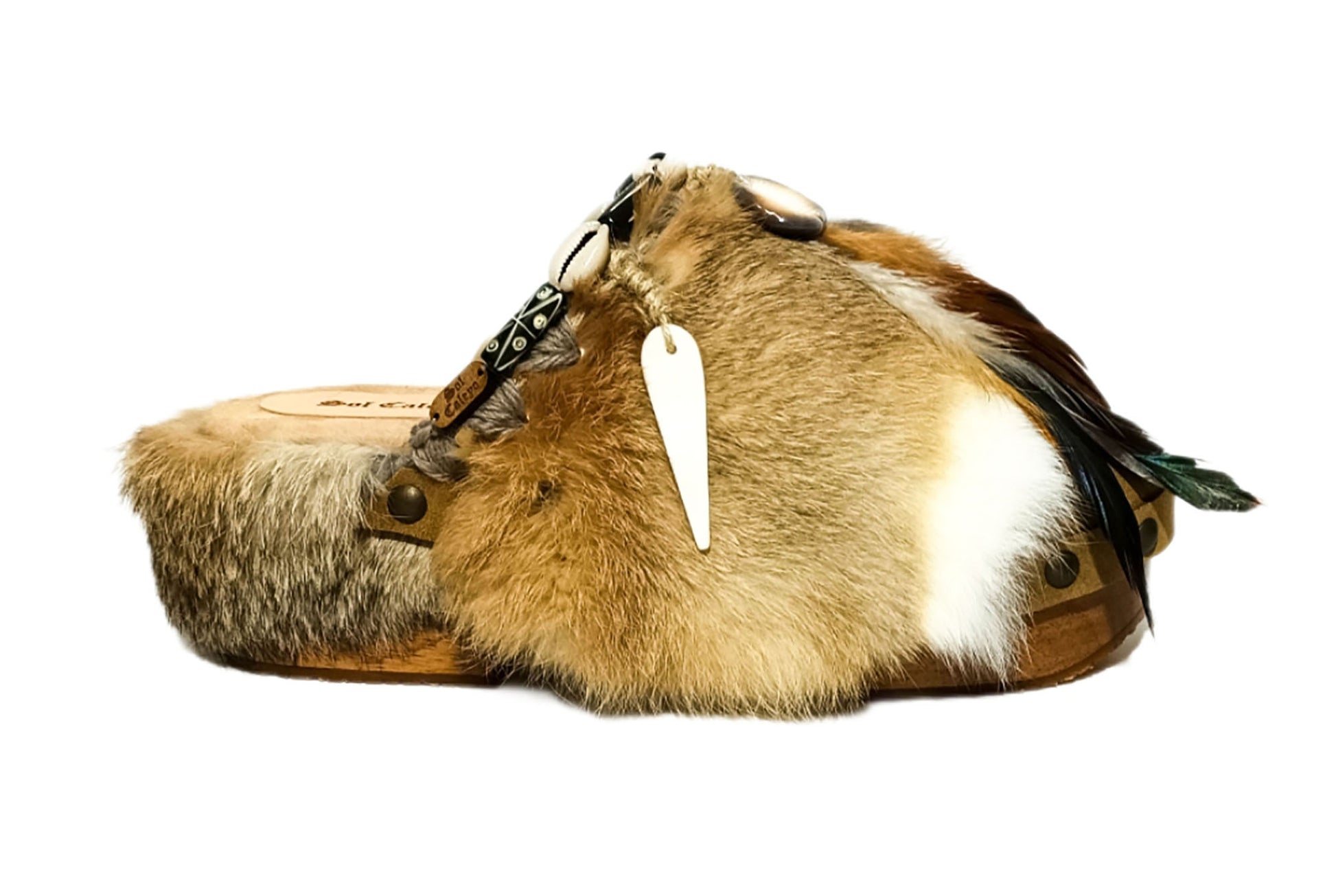 Platform clogs made of leather and rabbit fur, decorated with horns, shells and feathers for a bohemian style. Sizes 34 to 47. The Viking Clogs are an exclusive design by Sol Caleyo.