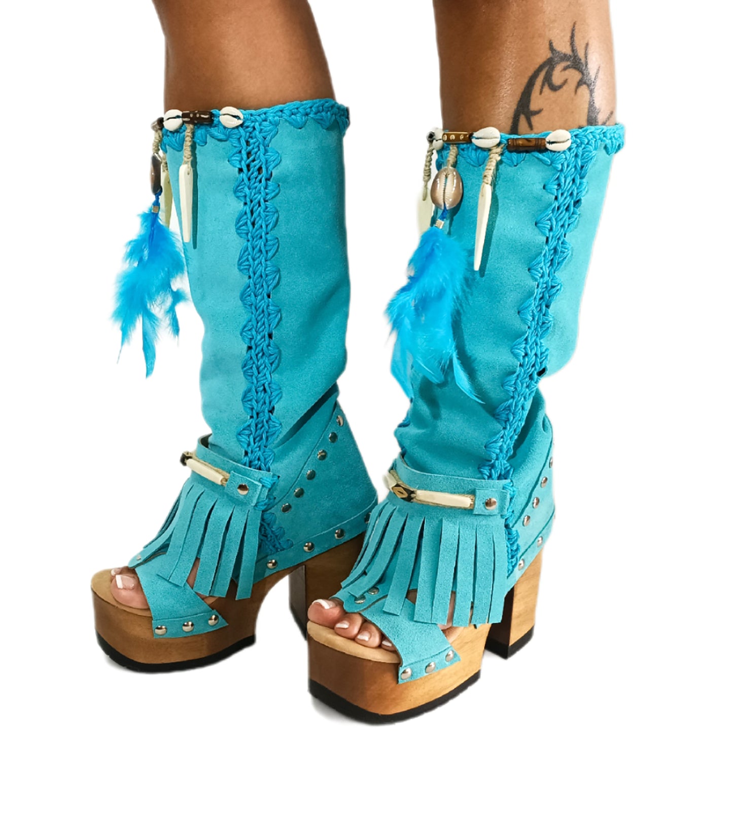 Handmade Rhapsody turquoise suede boho boots by Sol Caleyo featuring natural feathers, horns, and shells on a 12cm wooden platform with a black tractor sole.