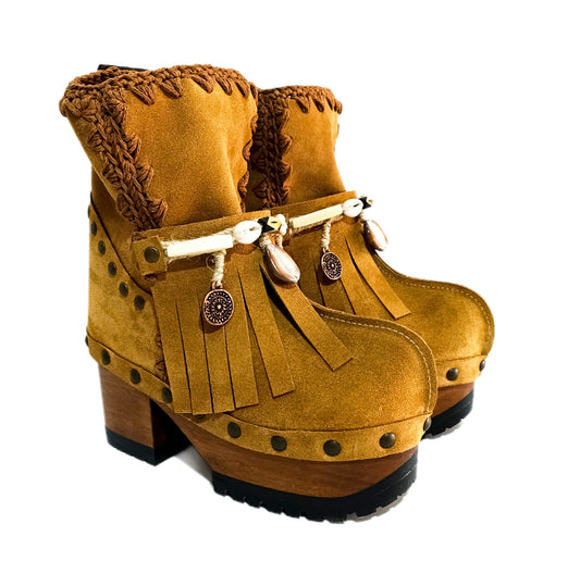 Bohemian style boots in camel suede leather. Clogs boots with handmade wooden heel. Bohemian style boots decorated with bangs, horns, coins and natural shell. High-end handmade footwear by Sol Caleyo.
