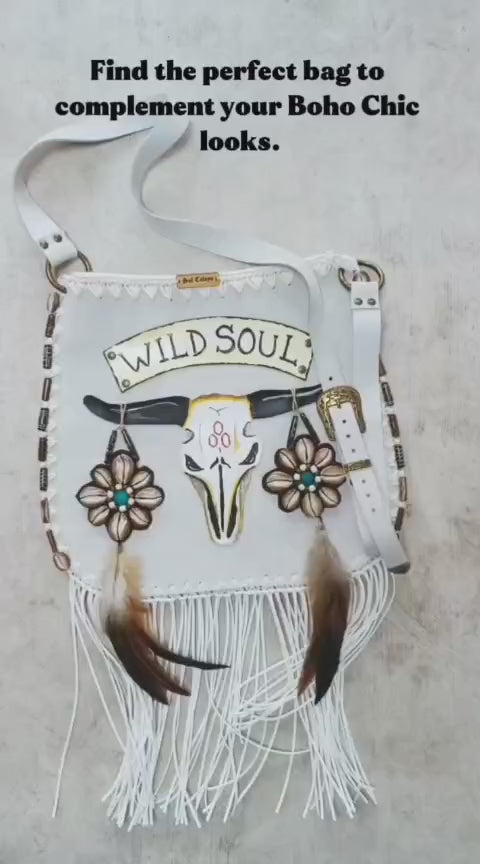 Bohemian-style white leather bag. Handmade leather bag with hand-painted buffalo decorated with shells, feathers, carved horn, and felcos. Handmade leather bag by Sol Caleyo.