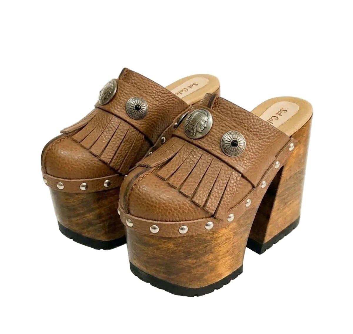 Side profile of Sol Caleyo Light Brown Indian Clogs XL featuring a high 17cm wooden platform, textured brown leather, decorative fringes, and antique metal conchos on a white background.
