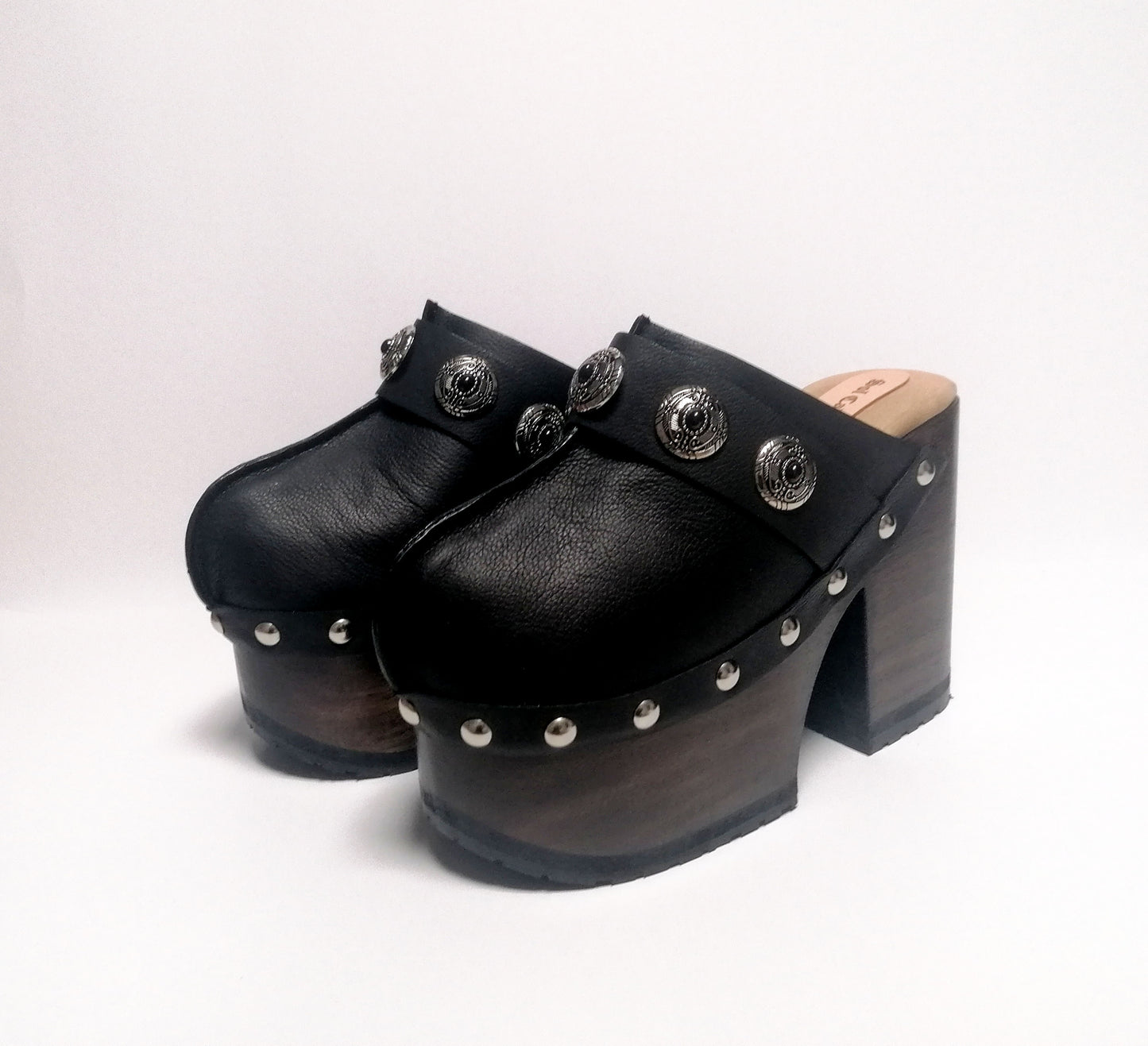 Vintage style black leather clogs. Super high heel clog decorated with vintage silver conchos. Bohemian style mule. Vintage 70's style platform clogs. Sizes 34 to 47. High quality leather shoes handmade by sol Caleyo. Sustainable fashion.