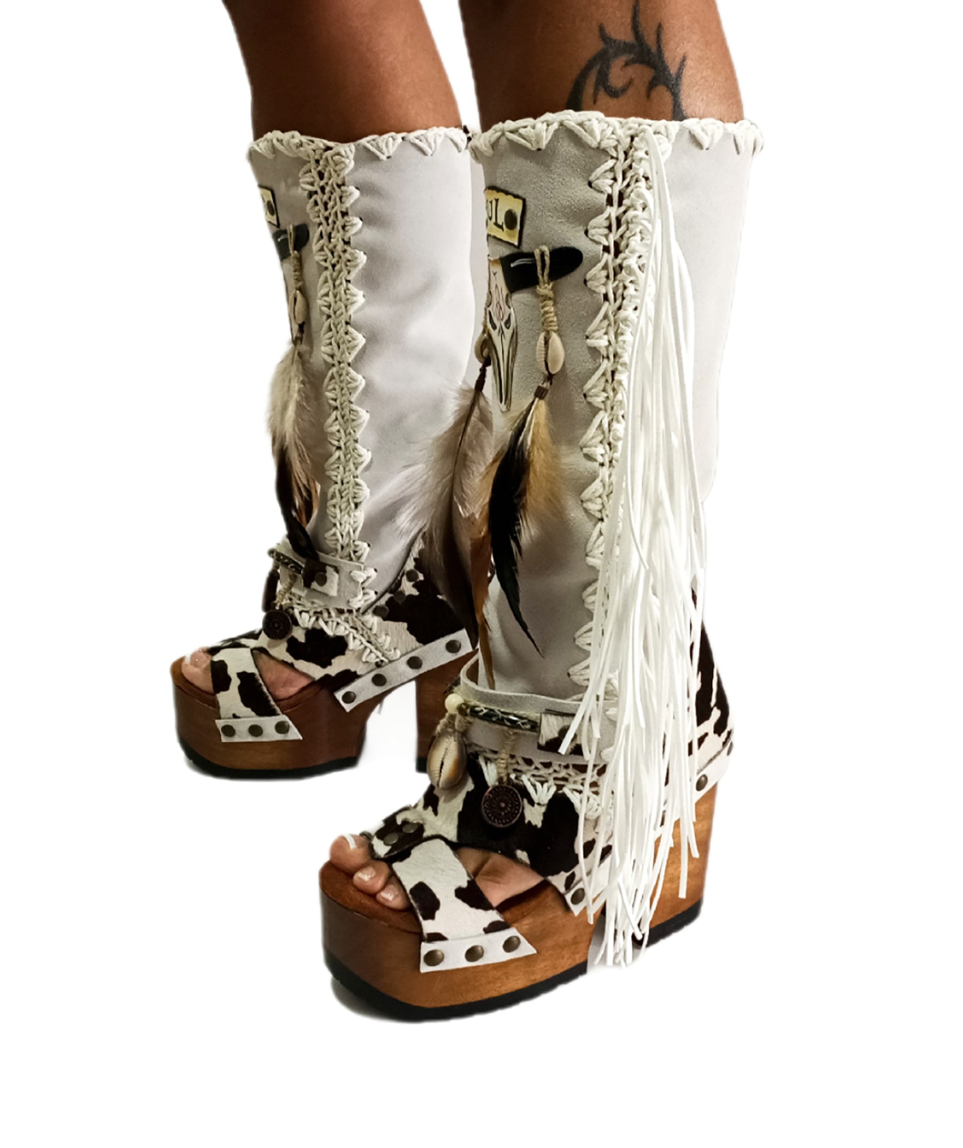 Handmade cowboy boots, white boots with cowhide and fringes. Cowboy style boots with hand painted buffalo, feathers, coins and natural shells. Vintage style platform boots. High-end leather footwear handmade by Sol Caleyo.