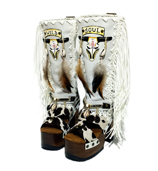 Handmade cowboy boots, white boots with cowhide and fringes. Cowboy style boots with hand painted buffalo, feathers, coins and natural shells. Vintage style platform boots. High-end leather footwear handmade by Sol Caleyo.