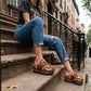Blogger wearing Oxford Clogs Cowhide Print with jeans and a vintage t-shirt, sitting on city steps for a boho-rock look.
