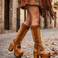 Beige handmade leather platform boots with fringe, coins, horns and shells on a 10 cm wooden heel by Sol Caleyo.