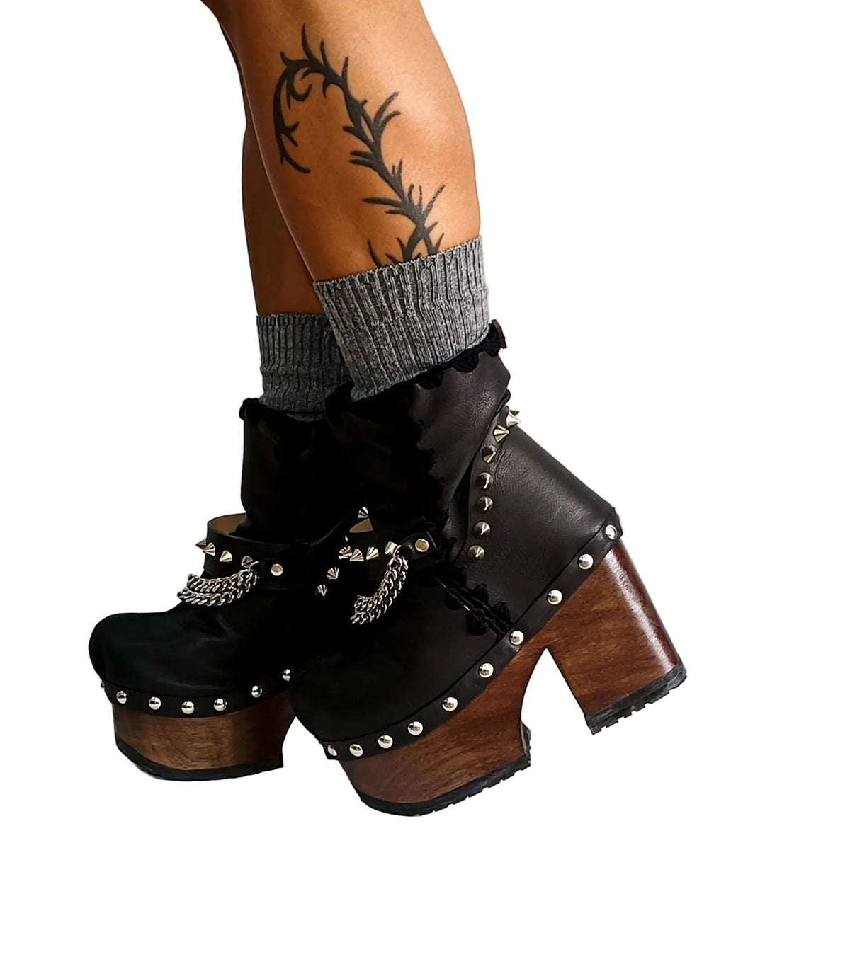 Handmade smooth black leather closed-toe platform ankle boots with silver pyramid studs, front chains and 12 cm straight wenge lacquered wooden heel by Sol Caleyo.