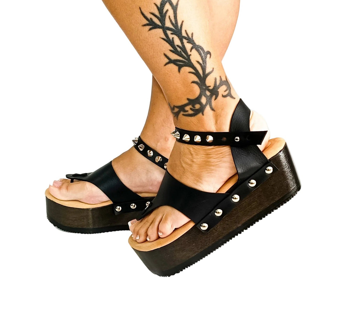 Handmade black leather wedge flip flop sandals with ankle strap, silver pyramid studs and 6 cm wenge lacquered wooden wedge by Sol Caleyo.