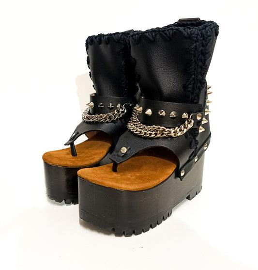 Handmade black leather flip flop wedge booties with silver pyramid studs, chains and 10 cm wooden wedge by Sol Caleyo.