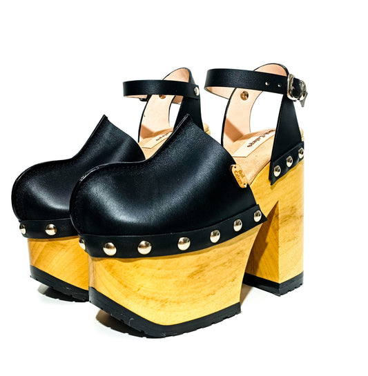 Handmade black leather Mary Jane platform clogs with adjustable silver buckle strap, studs and 14 cm wooden heel by Sol Caleyo.