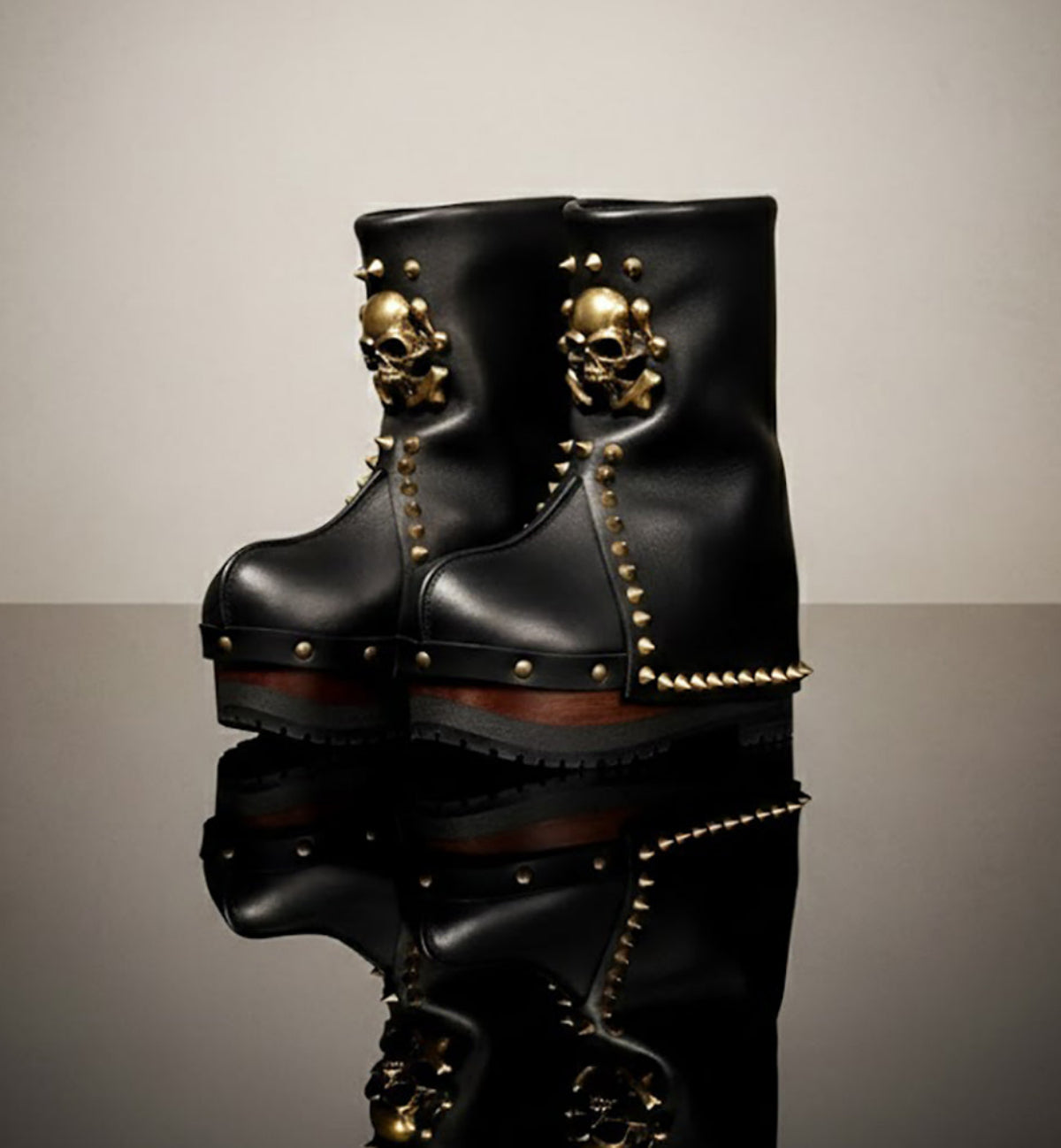 Handmade smooth black leather mid-calf wedge boots with old-gold metal skull, pyramid studs and 8 cm wenge lacquered wooden wedge by Sol Caleyo.