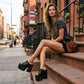 Black handmade leather mule sandals with 17 cm bell-style heel and 11 cm wooden platform by Sol Caleyo .