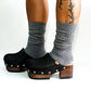 Handmade smooth black leather closed-toe platform mule clogs with round flat silver studs and 7 cm wenge lacquered wooden heel by Sol Caleyo.