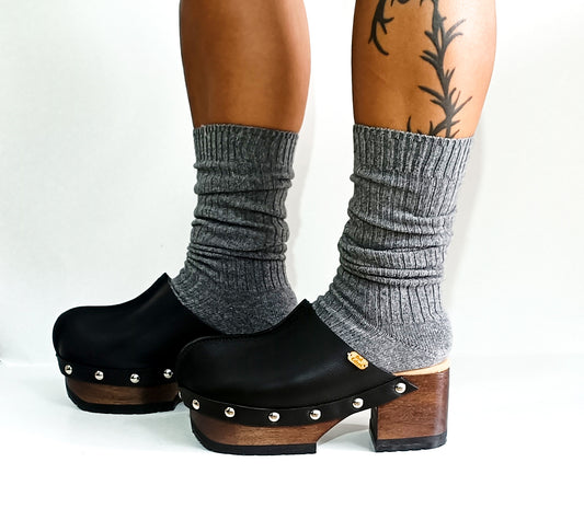 Handmade smooth black leather closed-toe platform mule clogs with round flat silver studs and 7 cm wenge lacquered wooden heel by Sol Caleyo.