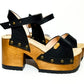 Handmade smooth black leather platform sandals with wide ankle strap and 8 cm natural lacquered wooden heel by Sol Caleyo .