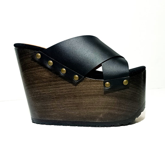 Jet black handmade leather wedge mule sandals with old-gold studs and 15 cm polished wooden wedge by Sol Caleyo.