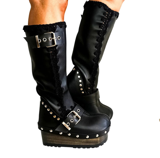 Handmade smooth black leather tall wedge boots with silver biker buckles and 8 cm wenge lacquered wooden wedge by Sol Caleyo.