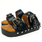 Handmade black leather low wedge sandals with silver buckles, eyelets and 3 cm wenge wooden wedge by Sol Caleyo.