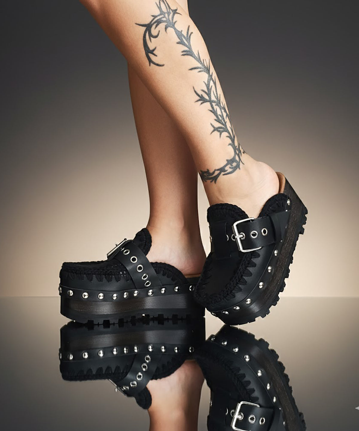 Handmade black leather wedge mule clogs with silver-tone buckle, studs and 6 cm wenge wooden wedge by Sol Caleyo.