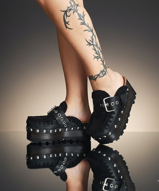 Handmade black leather wedge mule clogs with silver-tone buckle, studs and 6 cm wenge wooden wedge by Sol Caleyo.