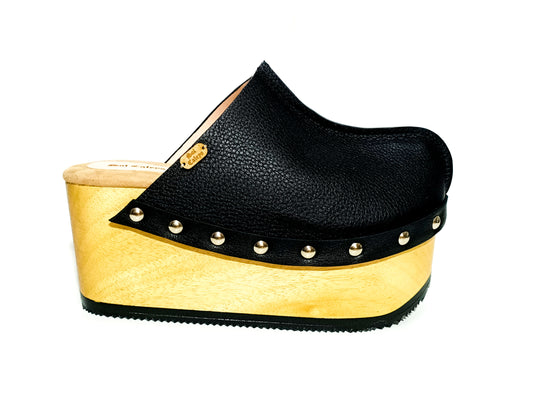 Handmade black leather open-back wedge mule clogs with silver studs and 9 cm wooden wedge by Sol Caleyo.